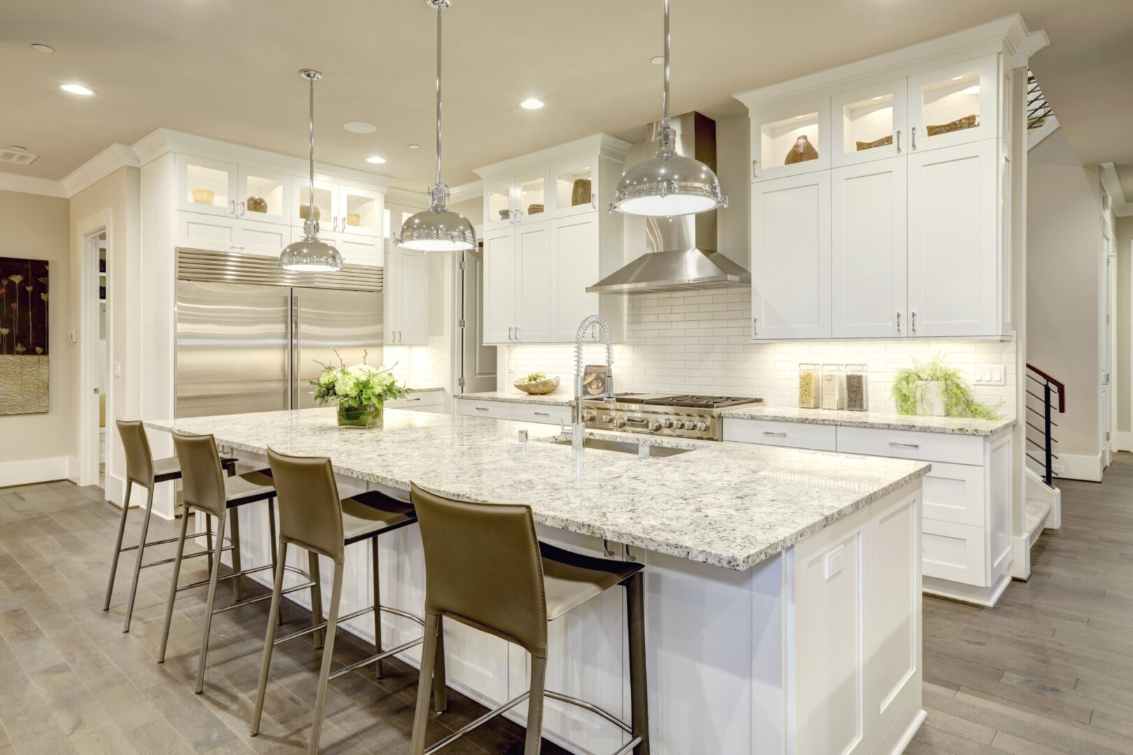 White kitchen with ceiling lamps and tall chairs